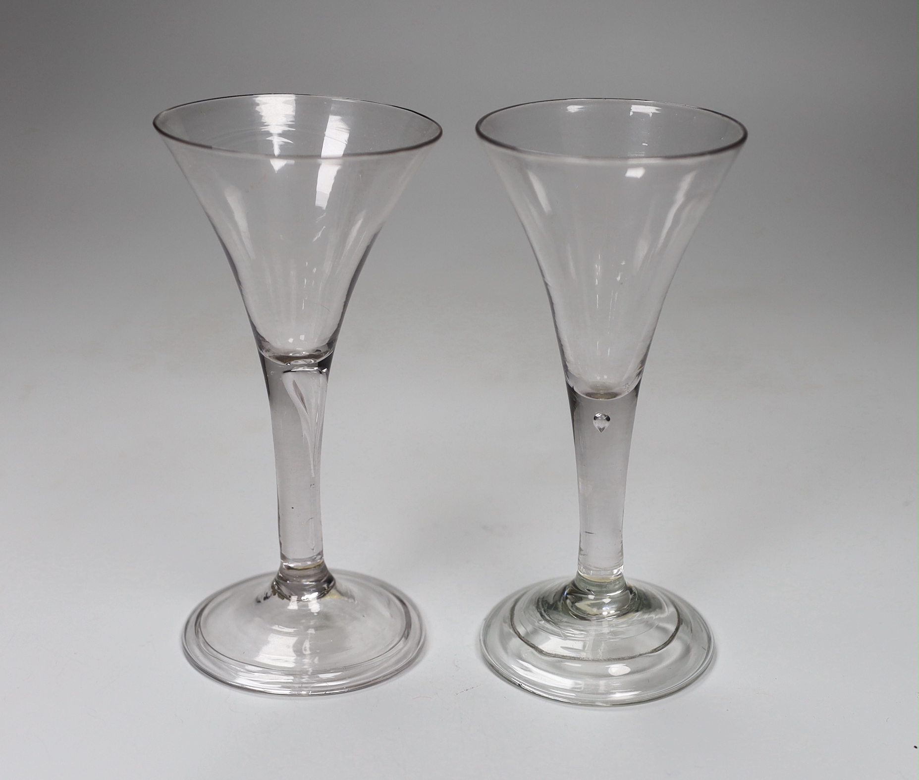 Two George II ‘drawn trumpet’ wine glasses, folded feet, tallest 16.5cm